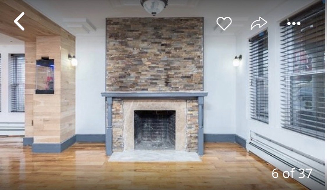 Completed stacked stone installation above a fireplace mantel